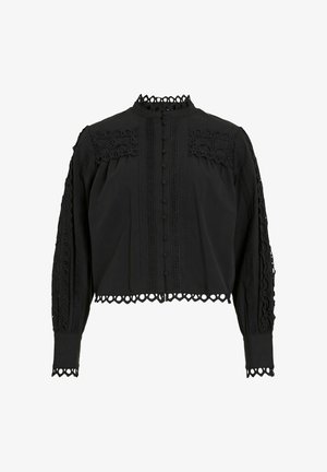Svart cropped bluse med lange ermer, med blondekant, knappelukking foran og intrikate broderier langs skuldrene og ermene.