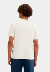 Roomkleurig T-shirt met korte mouwen, een ronde hals en een reguliere pasvorm. Zachte katoenen stof met zichtbare stikseldetails.