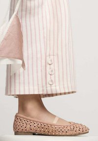Bailarinas color durazno con acentos texturizados, que presentan una punta redondeada y un diseño adornado. Tela ligera a rayas con botones en el dobladillo.