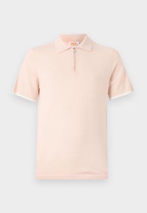 Polo shirt van lichtroze stof, met een korte rits sluiting en contrasterende witte accenten op de mouwen en de kraag.