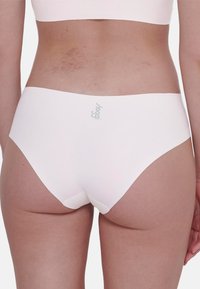 Vita sömlös brief med en mjuk, elastisk textur och en diskret logotyp på baksidan. Har en medelhög skärning och sömlösa kanter för extra komfort.