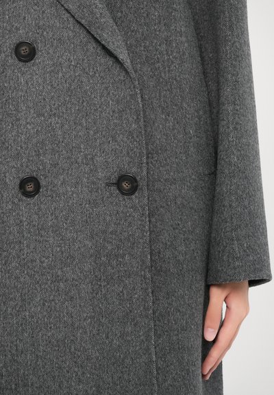 Cappotto in misto lana grigio con motivo a spina di pesce, design a doppio petto e bottoni neri. Presenta una silhouette rilassata e tasche laterali.