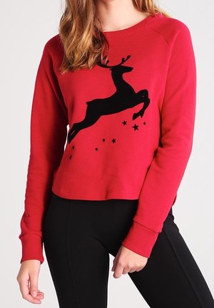 Felpa rossa con silhouette di un renna nera decorata con stelle, realizzata in un morbido tessuto, design corto e polsini a coste.