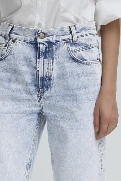 Svijetloplave traperice visokog struka u opuštenom kroju, s izblijedjelom teksturom, suptilnim borama i srebrnim detaljima sprijeda.