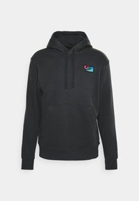 Svart hoodie av mjukt tyg. Har en framficka, justerbar snörning i huvan och en färgglad Nike-logotyp på bröstet.