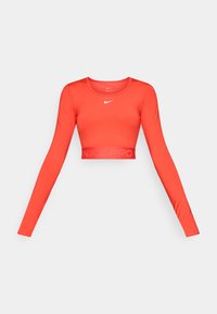 Red long-sleeve cropped athletic top made of stretchy fabric, featuring a round neckline and a branded elastic hem with "NIKE PRO" in a subtle design.