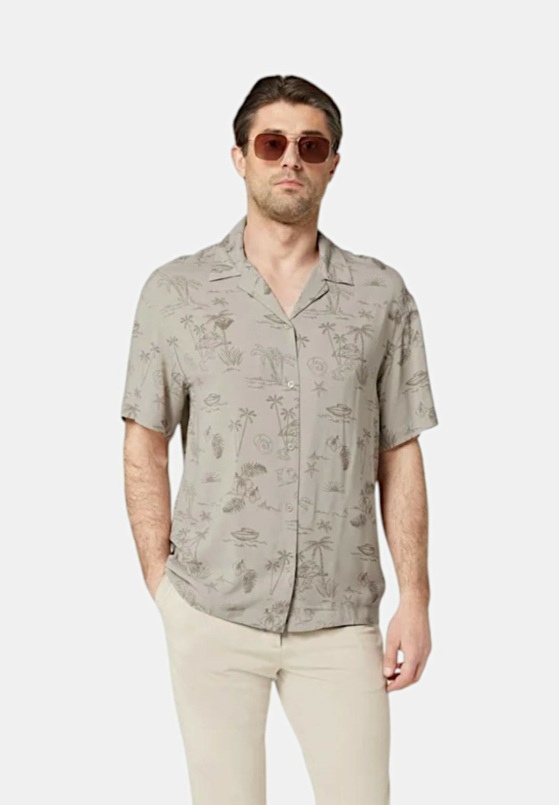 Camicia grigia chiaro a maniche corte con palme e motivi tropicali, design con bottoni, tessuto morbido, abbinata a pantaloni beige.