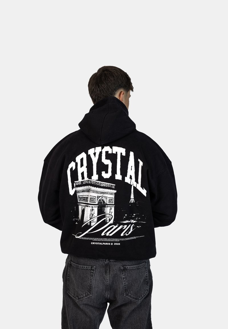 Felpa nera con cappuccio caratterizzata da una grande stampa grafica sul retro, che mostra l'Arc de Triomphe e la Torre Eiffel, con il testo "CRYSTAL Paris".