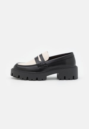 Sorte og cremefarvede loafers med en chunky sål, lavet af glat læder. Med en kontrasterende detalje hen over vristen og ribbet kantdetaljering.
