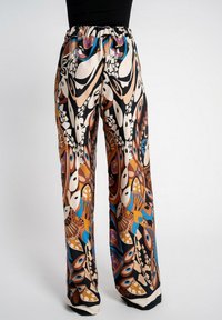 Miękkie, szerokie spodnie z kolorowym kwiatowym i abstrakcyjnym wzorem w odcieniach brązu, niebieskiego i czarnego. Elastyczny pas dla wygody.