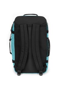 Vue arrière d'un sac à dos bicolore, avec un tissu noir et turquoise, des bretelles rembourrées réglables, une poignée supérieure et une poche latérale en filet.