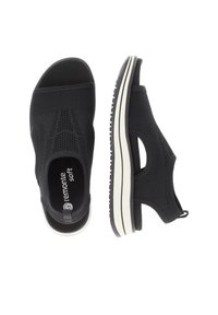 Schwarze Slippers aus atmungsaktivem Mesh-Obermaterial, mit elastischen seitlichen Ausschnitten und einer weißen Gummisohle mit rutschfester Oberfläche.