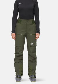 Gröna vattentäta skidbyxor med rak passform, utrustade med fickor och en logotypapplikation. Tillverkade av hållbart material med texturerade detaljer.