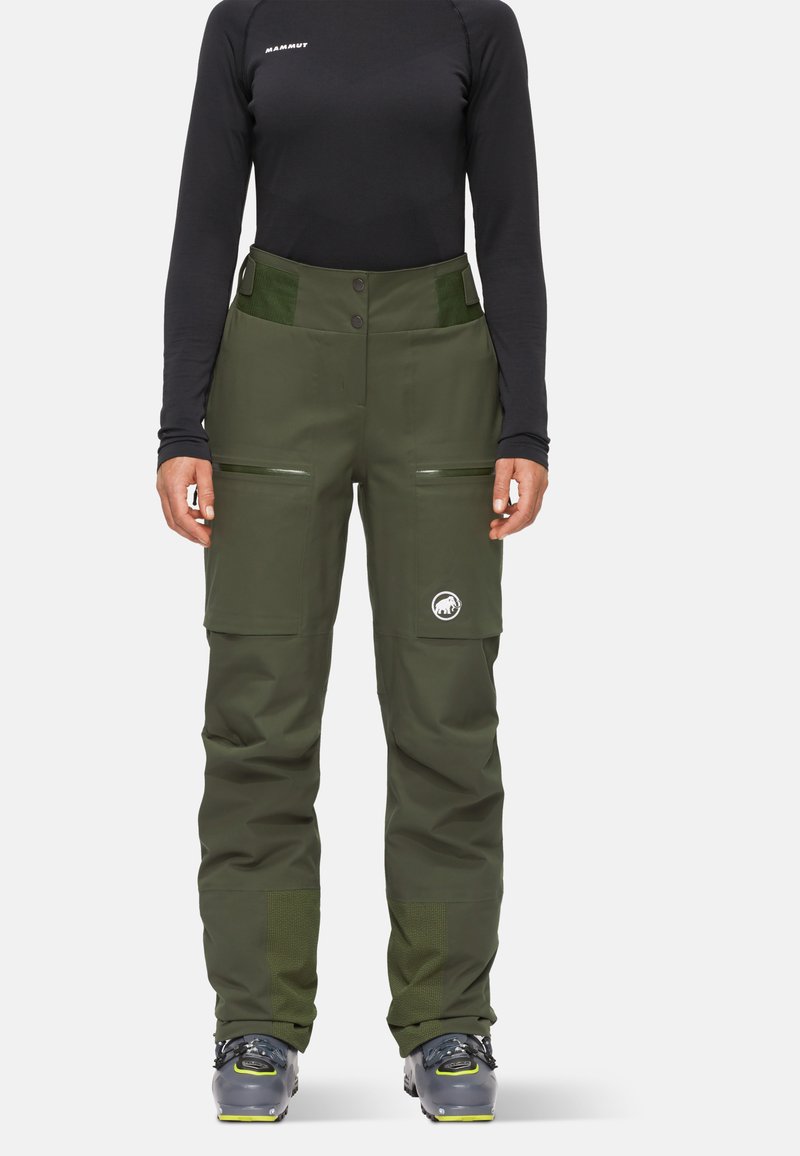 Gröna vattentäta skidbyxor med rak passform, utrustade med fickor och en logotypapplikation. Tillverkade av hållbart material med texturerade detaljer.