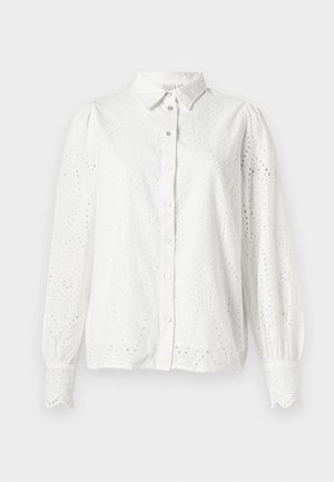 Valkoinen puuvillapaita pitkillä hihoilla, nappikiinnitys edessä ja silmäreikäyksillä varustettuna, jossa on paisley-kuvio. Pyöreä kaulus ja kerätty hihansuu.