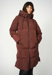 Burgundy pufferjacka med huva, med dragkedjestängning, sidofickor och stickad quiltdesign. Tillverkad av ett mjukt, vattenavvisande material.