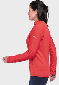 Rote, langärmelige Jacke aus strukturiertem Stoff mit hohem Kragen. Sie verfügt über eine figurbetonte Passform und das Logo auf dem linken Ärmeln.