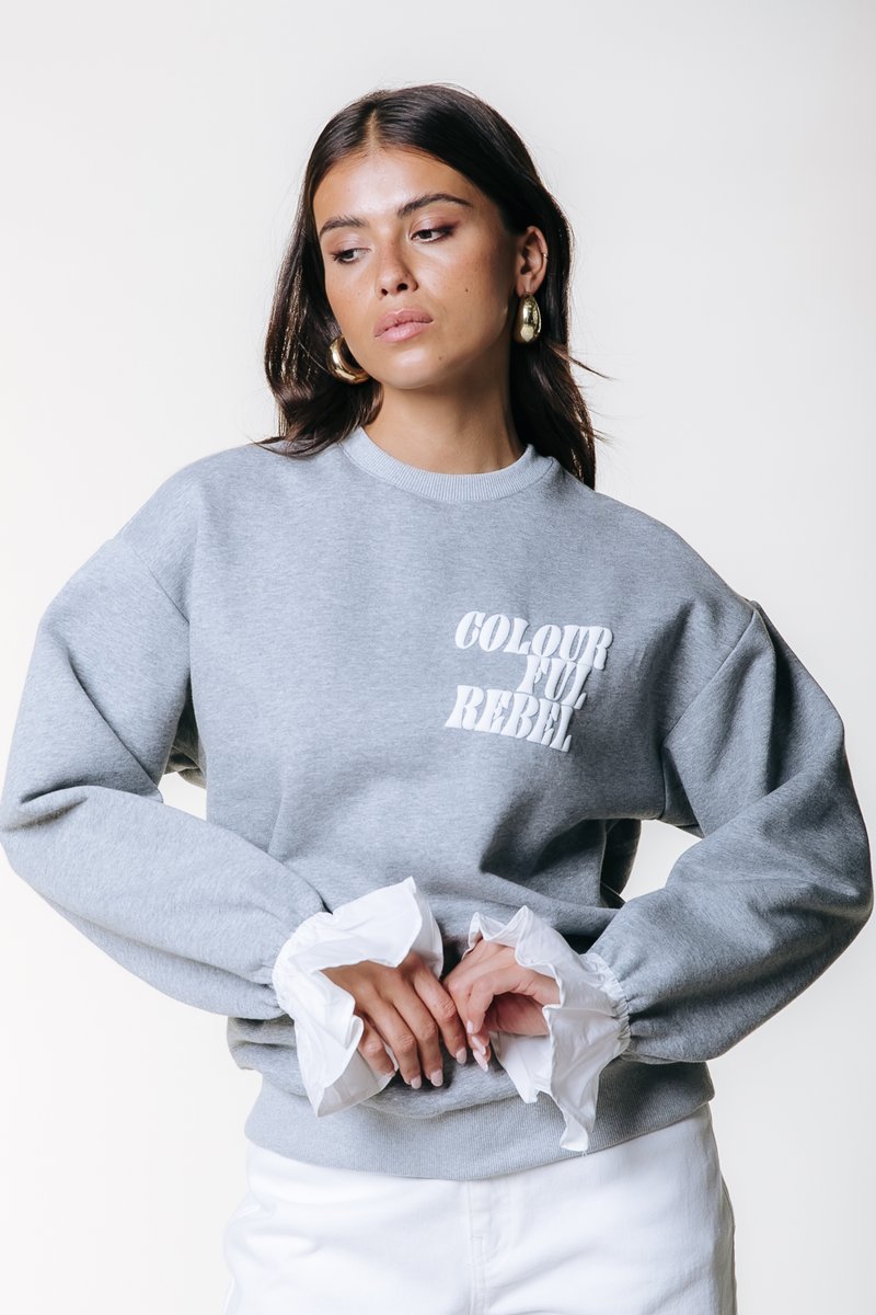 Γκρι φούτερ με λευκή επιγραφή "COLOURFUL REBEL", διαθέτει φουσκωτά λευκά μανσέτες και άνετη εφαρμογή. Απαλή ύφανση και ριμπ λαιμόκοψη.
