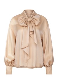 Blusa beige realizzata in un tessuto lucido, presenta un grande fiocco al collo, maniche a palloncino e polsini aderenti. Tessuto liscio con una lucentezza sottile.