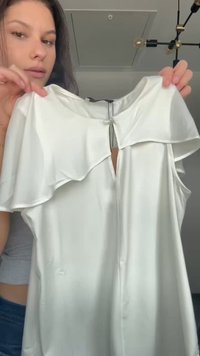 White satin dress with flutter sleeves and a keyhole detail at the back. Smooth texture, knee-length, and minimal design elements.