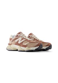 Braune Wildleder- und Mesh-Sneaker mit einer klobigen cremefarbenen Sohle, weißen Schnürsenkeln und Logo-Akzenten. Verfügt über einen gepolsterten Kragen und eine strukturierte Oberseite.