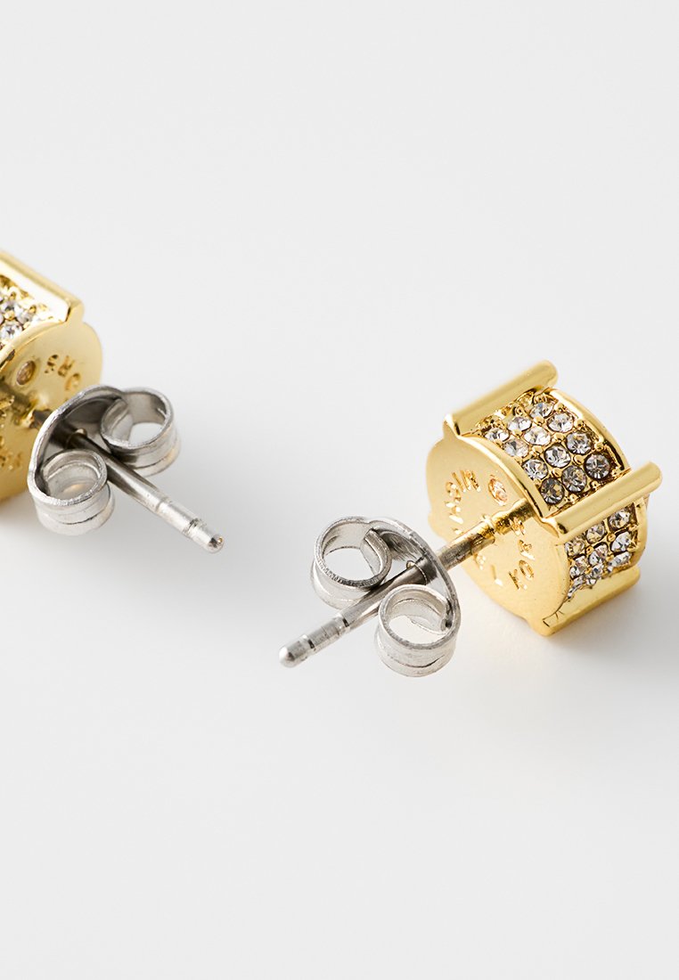 Boucles d'oreilles en or avec un design cylindrique, ornées de strass transparents et d'un fermoir à tige en argent. Surfaces texturées et accents brillants.