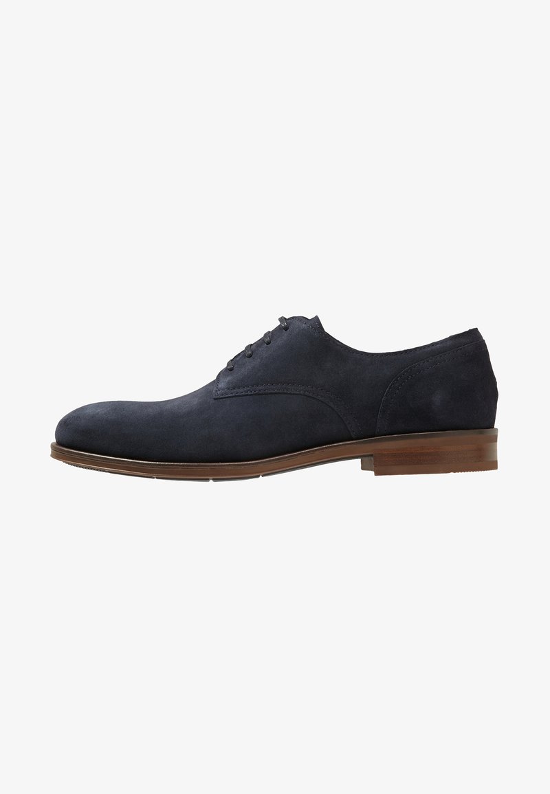 Chaussure Oxford pour homme en daim bleu foncé avec laçage fermé et semelle et talon en cuir marron, vue de profil droit.