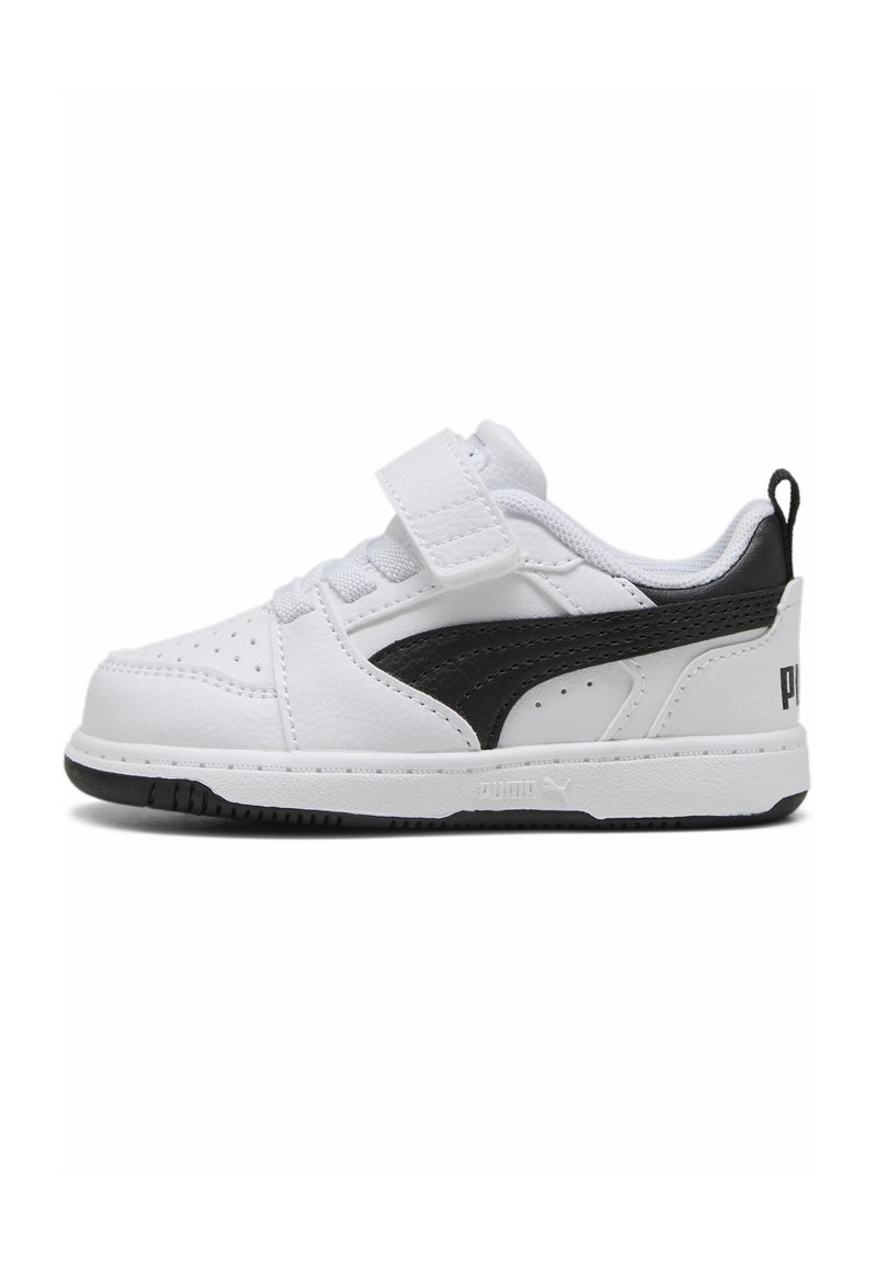 Baskets en cuir blanc avec accents noirs, présentant un design Swoosh contrasté, une sangle Velcro et une semelle en caoutchouc texturé.