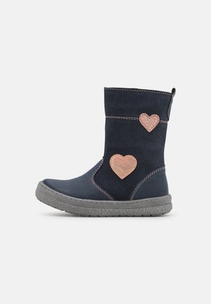 Botte enfant en daim bleu marine avec semelle grise et deux patchs en forme de cœur marron sur le côté.