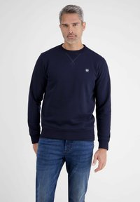 Navy Sweatshirt mit Rundhalsausschnitt, gerippten Bündchen und Saum, mit einem kleinen Logopatch auf der Brust, aus weichem Baumwoll-Mix gefertigt.
