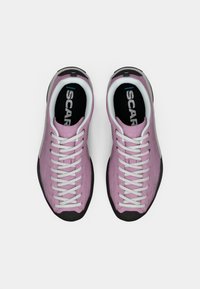 Sapatos de caminhada roxos com atacadores brancos, parte superior texturizada, sola de borracha preta e palmilha almofadada com a marca "SCARPA".