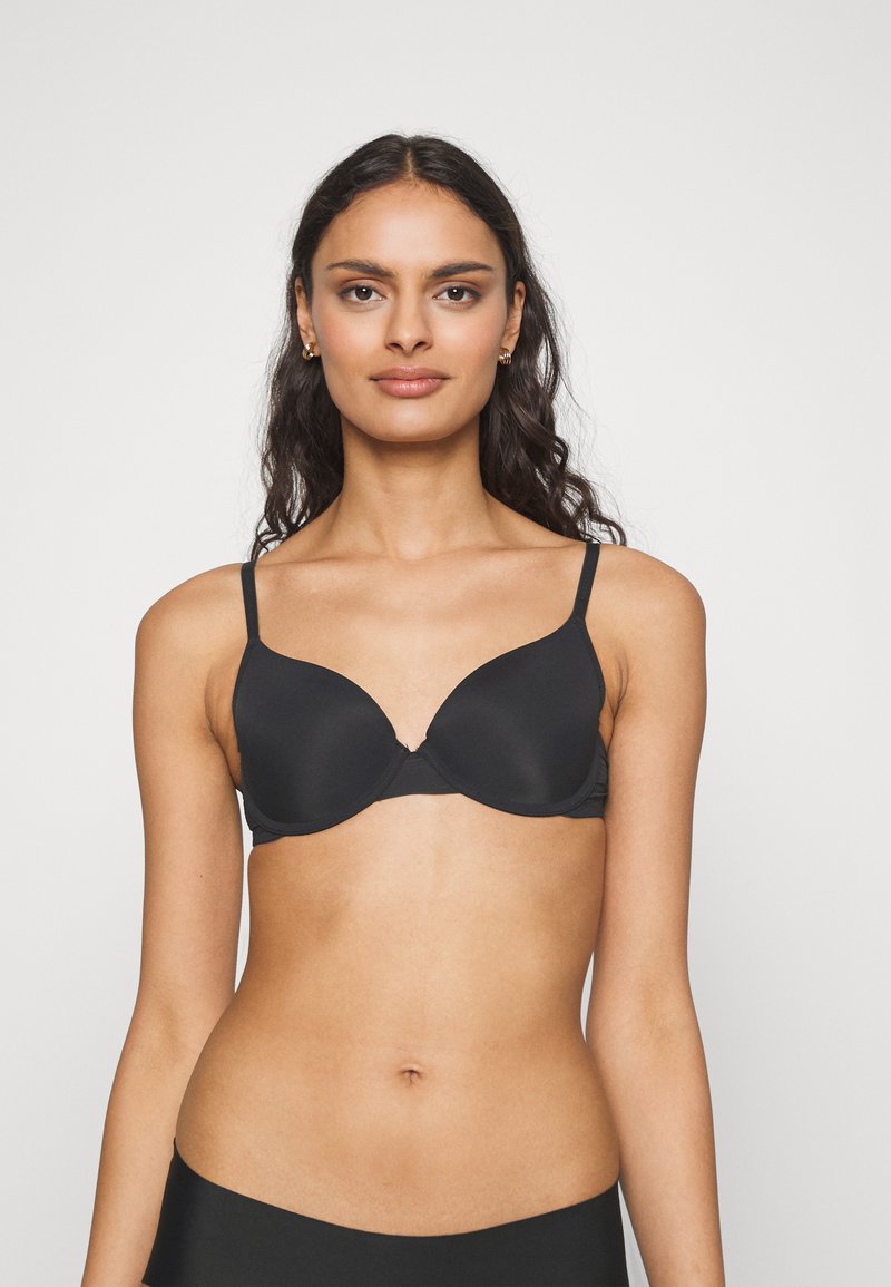 Black padded bra with adjustable straps. Smooth fabric, seamless design, and a subtle U-shaped neckline for an understated look.