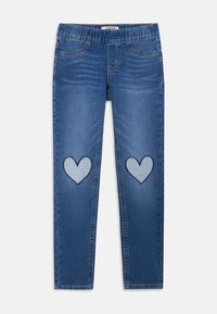 Leggings in denim blu con una cintura elastica, due tasche anteriori e toppe a forma di cuore in contrasto su ciascun ginocchio.
