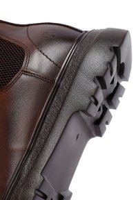 Stivale in pelle marrone con parte superiore testurizzata, pannello in rete e suola in gomma con un design antiscivolo. Punta rinforzata per una maggiore durabilità.