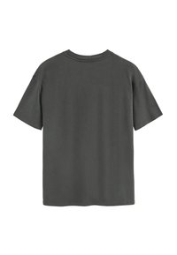 Camiseta de color gris oscuro, de manga corta y con cuello redondo. Textura suave, corte relajado y sin patrones ni gráficos visibles en la parte posterior.