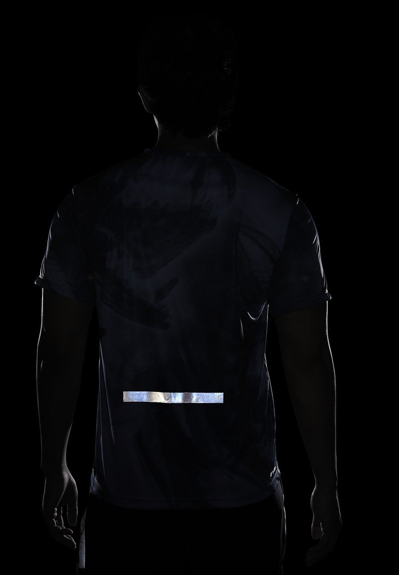 Maillot de sport pour homme en tissu sombre avec une bande réfléchissante dans le bas du dos ; présente un motif abstrait subtil dans des nuances plus sombres.