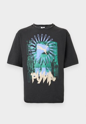 T-shirt nera Puma con grafica astratta verde e blu, logo Puma beige e testo stilizzato sul davanti.