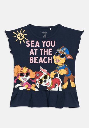 T-shirt enfant bleu marine avec les chiens de la Pat’ Patrouille portant des lunettes de soleil et le texte « SEA YOU AT THE BEACH » sous un soleil jaune.