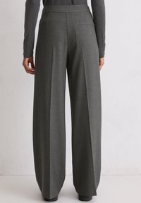 Široke sive hlače napravljene od teksturirane tkanine, sa ravnim krojem, strukom i jednim stražnjim džepom.