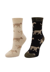 Ett par ankelsockor, en beige och en svart, båda mönstrade med silhuetter av vandrande leoparder i kontrasterande färger.