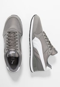 Graue Laufschuhe aus Mesh und Wildleder. Verfügen über weiße Akzente und Branding. Geschlossenes Schnürsystem und strukturiertes Gummilaufsohle.