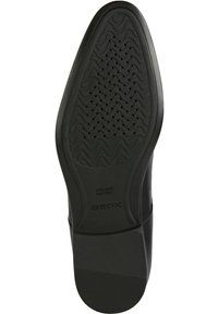 Melnas gumijas apavu zoles ar teksturētu viļņu rakstu un mazām drenāžas atverēm. Apskatāma zīmola nosaukums "GEOX" un "ITALIAN PATENT" iegravēts.