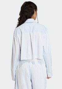 Modrobiela pruhovaná krátka košeľa s plisovaným zadným dielom, s dlhými rukávmi a klasickým golierom, vyrobená z ľahkej tkaniny.