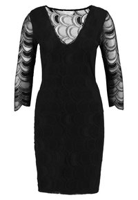 Robe noire à manches longues, avec un décolleté plongeant en V, un tissu texturé et un motif circulaire sur toute la surface. Silhouette épurée, longueur au genou.