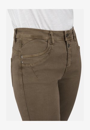 Braune Denim-Jeans mit einem taillierten Design, das einen klassischen Fünf-Taschen-Stil und kontrastierende Nähte aufweist. Der Stoff hat eine glatte Textur.