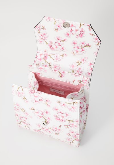 Floral handbag with a white base, featuring pink blossom patterns, a snap closure, and a soft pink interior lining with a compartment.
