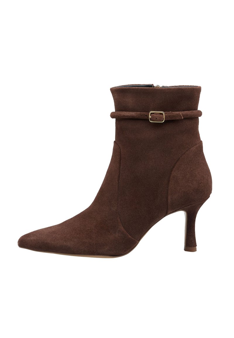 Stivaletto in suede marrone con punta affusolata, tacco sottile e una fascia regolabile con una piccola fibbia dorata. Texture liscia, design elegante.