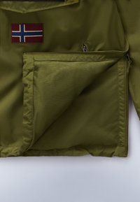 Das Innere der grünen Nylonjacke verfügt über eine Netzinnentasche und ein norwegisches Flaggenaufnäher auf der äußeren Schicht. Reißverschluss- und Nahtdetails sind sichtbar.