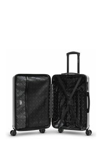 Valise rigide argentée ouverte, présentant un intérieur noir avec un motif, un compartiment zippé, des sangles croisées et quatre roues pour la mobilité.