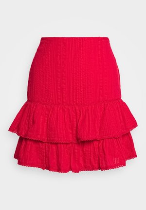 Minifalda roja brillante con textura, dobladillo con volantes de doble capa y delicado borde de encaje a lo largo de los bordes, mostrada sobre un fondo liso.